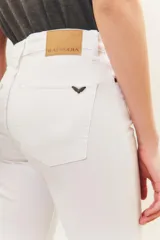 Pantalón jean blanco de tiro medio y calce slim, con largo al tobillo.