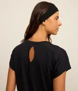 Top deportivo negro de poliamida, con escote redondo y breteles medianos. Presenta detalle contrastante color naranja en el bajo y en los bordes de las mangas.