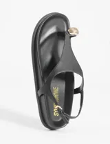 Sandalias negras de cuero vegano con tira delantera tipo ojota y detalle metálico dorado.