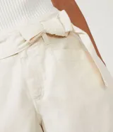 Short corto color marrón, de tiro medio, con cinturón de la misma tela y bolsillos laterales.