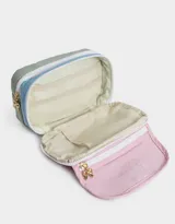 Cartuchera rectangular de tela estampada multicolor con divisiones internas, bolsillo frontal de PVC transparente con estampado de ositos y cierre con cremallera. Incluye un dije metálico con forma de moño.