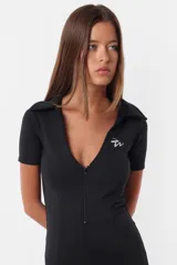 Mono corto negro de microfibra con calce slim, cuello polo, escote en V pronunciado, cierre frontal y mangas cortas.