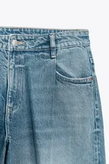 Bermudas de jean celeste de tiro bajo, con bolsillos delanteros y traseros, pinzas delanteras y cierre frontal con cremallera y botón metálico.
