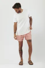 Short de baño con estampado de hojas de palmera en tonos beige, verde y naranja.