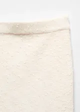 Minifalda color crema de punto con textura, tiro medio, diseño recto y cintura elástica.