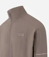 Campera deportiva color marrón, con cuello alto, cierre frontal con cremallera, manga larga, bolsillos laterales y detalles de etiqueta aplicada y rayas.
