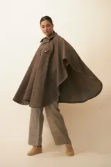 Poncho unisex de lana fina color marrón claro, con cuello polo, cartera con broches a presión y bolsillo ojal.
