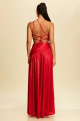 Vestido largo de fiesta color rojo brillante, con escote halter asimétrico, abertura en el abdomen y falda con tajo alto.