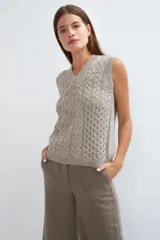 Chaleco de punto color beige con cuello en V y diseño de trenzas.