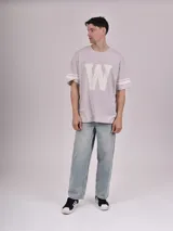 Remera negra de corte holgado con mangas cortas y dos rayas blancas en cada manga.