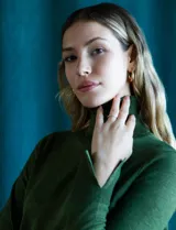 Polera de punto fino marca Nienty, de color verde, con cuello alto y mangas largas que presentan un detalle de tajo en los puños.