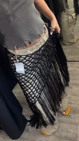 Pareo artesanal tejido a mano en hilo de seda viscosa, color negro, con diseño de red y flecos largos en el borde.