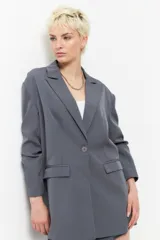Blazer gris con diseño clásico, dos bolsillos de solapa y botón a tono, ideal para diversas ocasiones.