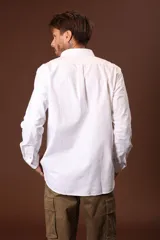 Camisa blanca de manga larga con cuello abotonado.