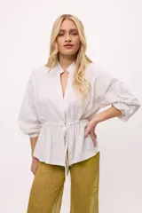 Chaqueta azul con cuello mao, mangas largas abullonadas y lazo en la cintura.