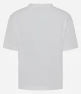 Remera blanca de algodón, con cuello redondo y manga corta. Presenta un estampado frontal con la frase "SOY FLOR. SOY LATINA" y un diseño floral con flores en relieve y hojas bordadas.