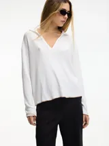 Sweater de punto blanco con cuello tipo polo y manga larga. Pespunte a contratono en la terminación.