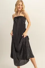 Vestido midi negro con textura plisada, escote halter y corte holgado.