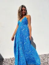 Vestido largo de tirantes finos con estampado paisley en tonos azules y dorados.