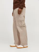 Pantalón cargo color beige de pierna ancha con fit amplio y tiro medio alto. Cuenta con bolsillos delanteros, traseros y laterales, cierre con cremallera y puños doblados.