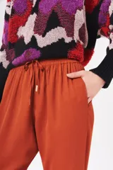 Pantalón color ladrillo con cintura elastizada y cordón ajustable.