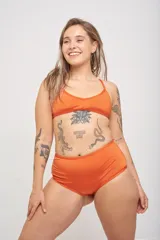 Corpiño de bikini verde con breteles finos que se cruzan en la espalda.