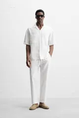 Pantalón azul marino de corte amplio, confeccionado en tejido de mezcla de algodón y lino. Cuenta con cintura elástica ajustable con cordón, bolsillos frontales y bolsillos traseros de vivo.