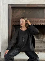 Sweater negro con brillos plateados, de corte holgado y mangas largas.