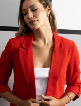 Blazer rojo de crepe marca Tahari, con cuello con solapa y abertura central. Tiene mangas 3/4 regulables con presilla y botón, bolsillos delanteros y forro interno.