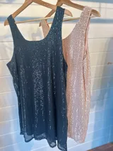Vestido corto sin mangas, cubierto de lentejuelas.