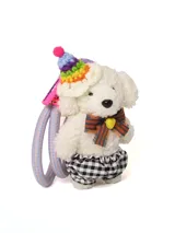 Llavero con forma de oso de peluche blanco con gorro de fiesta tejido a crochet con pompon y moño a rayas. El llavero tiene dos cintas elásticas para sujetar el pelo.