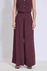 Pantalón ancho de tiro alto color vino, con pliegues frontales y bolsillos laterales.