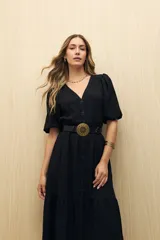 Vestido midi color marrón claro, con escote en V, mangas cortas abullonadas, botones frontales y falda con volantes.