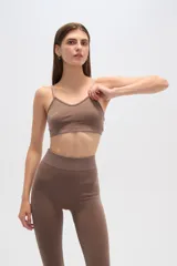 Top deportivo gris con breteles finos, corte al cuerpo y cuello en V.