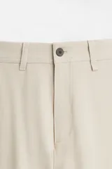 Pantalón slim fit negro confeccionado en tejido con elasticidad en ambas direcciones. Cuenta con bolsillos frontales y traseros de vivo con botón. Cierre frontal con cremallera y botón.