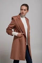 Saco blazer color beige, de corte clásico con solapas y cierre frontal con botones.