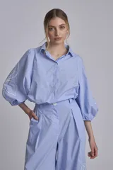 Camisa azul marino con bordados de flores blancas en mangas y falda.