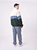 Buzo de polar con cierre a la altura del cuello, diseño a bloques de color blanco, azul y verde.