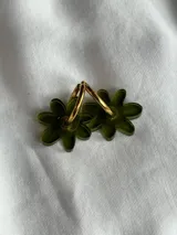 Aros colgantes plateados con dije de flor acrílica color dorado.