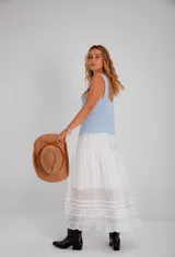 Falda larga blanca de estilo romántico, con volados en el ruedo y detalles de puntilla y encaje bordado.