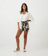 Short runner de viscosa con estampado de hojas en tonos beige y negro. Tiene cintura elástica con cordón ajustable, dos bolsillos laterales y dobladillo redondeado.