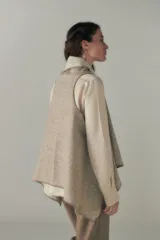 Chaleco marrón con diseño a cuadros, solapas anchas y bolsillos laterales.