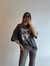 Remerón gris oscuro con estampado frontal de fotos en blanco y negro y texto en blanco.