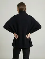 Capa tejida color fucsia, con cuello alto abotonado y mangas cortas estilo japonesa. Tejido de punto grueso.