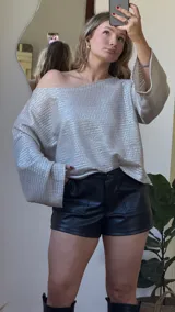 Blusa plateada de tejido metalizado con escote bote que puede usarse recto o caído en un hombro.