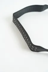 Cartera negra con correa corta para el hombro y tachas plateadas.