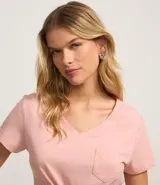 Blusa blanca de algodón con cuello en V, manga corta y bolsillo frontal.
