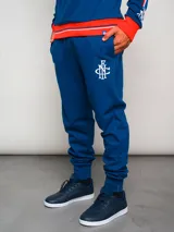Pantalón de jogging azul con puños ajustados, cintura elástica con cordón y escudo del Club Nacional de Football en la pierna izquierda.