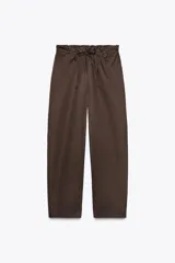 Pantalón marrón tipo barrel, de tiro medio con cintura elástica ajustable con lazada, bolsillos laterales y falsos bolsillos de vivo en la espalda.