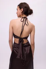 Vestido midi amarillo de satén con escote halter, trenzas en cuello y cintura, cut-outs laterales y falda recta.